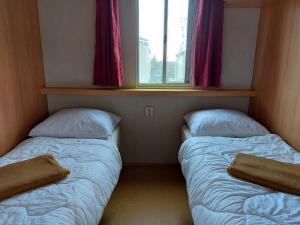 Tempat tidur dalam kamar di Stacaravan 169 5* camping De kuilart in Friesland