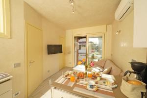 una cocina y una sala de estar con una mesa con comida. en Appartamento Elena, en Manerba del Garda