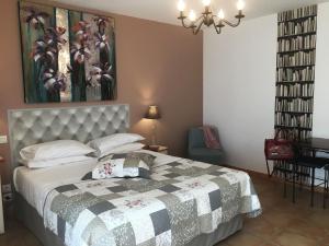 a bedroom with a bed and a dresser at Hotel Les Ambres in Roussillon