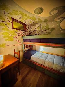 a bedroom with a bed with a tree mural on the wall at La Maison Des Artistes - Mont Blanc in Morgex