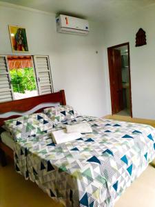Kitnet em Alter do Chão في ألتر دو تشاو: غرفة نوم عليها سرير ولحاف