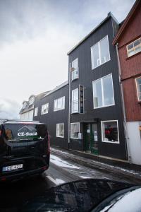 una furgoneta estacionada frente a un edificio negro en Ruba Apartments - Downtown - Marina - Old Town - Tórshavn, en Tórshavn