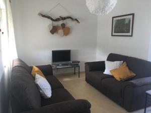 ein Wohnzimmer mit 2 Sofas und einem TV in der Unterkunft Casa Quintião in Ferragudo