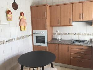 uma pequena cozinha com uma mesa preta e um fogão em Casa Quintião em Ferragudo