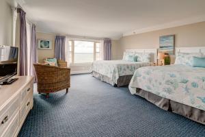 1 dormitorio con 2 camas, TV y ventana en The Heights Hotel, en Falmouth
