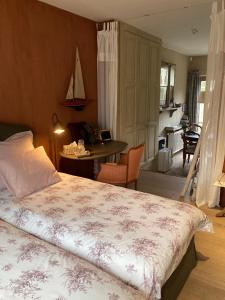 sypialnia z łóżkiem i biurkiem oraz kuchnia w obiekcie De Epicurist w mieście Hasselt