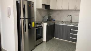 a kitchen with a stainless steel refrigerator and a sink at KattySuit in Salinas