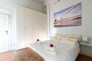 a white bedroom with a bed with towels on it at Appartamento Agata in San Felice del Benaco
