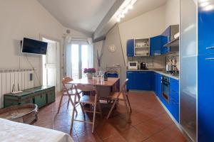 サン・フェリーチェ・デル・ベナーコにあるAppartamento Agataのキッチン(青いキャビネット、テーブル、椅子付)