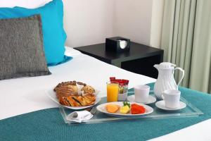 a tray with two plates of food on a bed at Hotel Rio 1300 in Cuernavaca