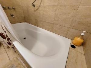 a white bath tub sitting in a bathroom at Dpto. luminoso, céntrico, nuevo: LA SERENA in Tandil