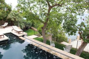 a swimming pool with a bench and a tree at El jardin Botánico Villa LUZ in Altea