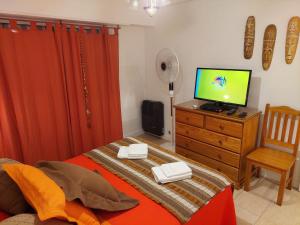 a bedroom with a bed and a television on a dresser at Dpto. luminoso, céntrico, nuevo: LA SERENA in Tandil