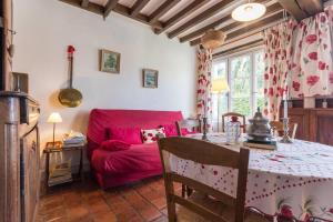 a living room with a table and a red couch at Gîte de Pierre in Champlin
