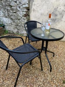 a table with a bottle of wine and a glass at Cosy 3-bedroom house, stones throw to beach in Weymouth