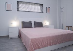 um quarto com uma cama grande e um cobertor rosa em Sea & View Villas em Kato Achaia