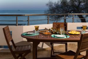 a wooden table with food and drinks on a balcony at Aroma of the Sea in Kissamos
