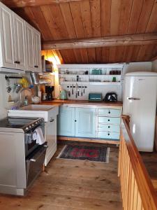 a kitchen with blue cabinets and a white refrigerator at Ålbyggården in Røros