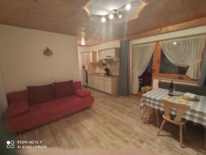 a living room with a red couch and a table at Haus Sonnenschein in Holzgau