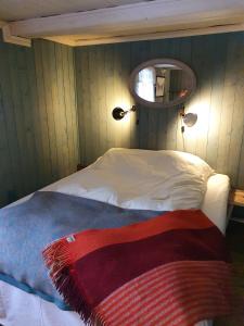 Schlafzimmer mit einem Bett und einem Spiegel an der Wand in der Unterkunft Ålbyggården in Røros
