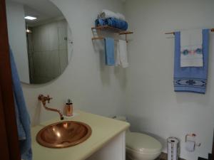 a bathroom with a sink and a toilet and a mirror at Patio Bonito in Jardin +56 photos