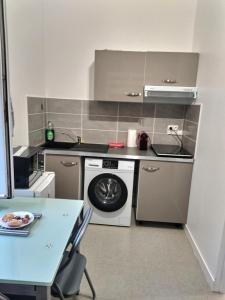 uma pequena cozinha com um fogão e um lavatório em SUPERBE STUDIO 3 FACE GARE em Évreux