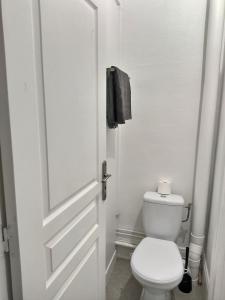 La salle de bains est pourvue de toilettes blanches et d'une porte. dans l'établissement SUPERBE STUDIO 3 FACE GARE, à Évreux