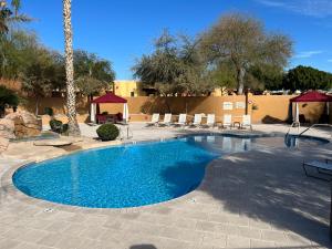 una piscina en un complejo con sillas y árboles en Monte Vista Village Resort Mesa 3 Bed 2 Bath Age 55 Plus Community, en Mesa