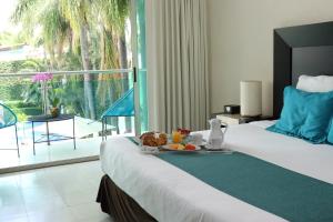 Una habitación de hotel con una cama con una bandeja de comida. en Hotel Rio 1300, en Cuernavaca