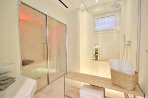 uma casa de banho com uma cabina de duche em vidro e um banco em I Giardini di Camogli - VILLA SÀRVIA, garden&pool em Camogli