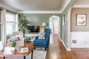 uma sala de estar com uma cadeira azul e um sofá em Pet Friendly - Large Families - Heart of Royal Oak - 5 Smart TVs em Royal Oak