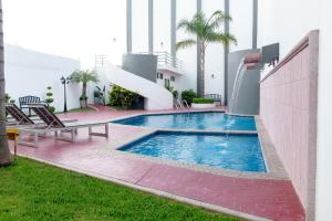 - une piscine sur le côté d'un bâtiment dans l'établissement Hotel Mirage, à La Piedad Cavadas