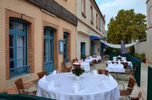 a group of tables with white table cloths on a patio at Aux Lys d'Or in Réalville