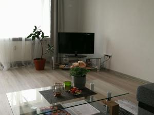 ein Wohnzimmer mit einem TV und einem Couchtisch in der Unterkunft Draugystės Apartment in Šiauliai