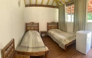 1 Schlafzimmer mit 2 Betten und einem Fenster in der Unterkunft Pouso dos Querubins in Tiradentes