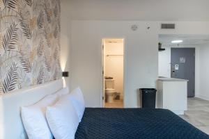 ein Schlafzimmer mit einem Bett mit weißen Kissen in der Unterkunft NEW - remodeled Studio close to Universal Studios in Orlando
