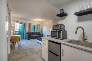 eine Küche mit einer Spüle und einer Mikrowelle in der Unterkunft NEW - remodeled Studio close to Universal Studios in Orlando