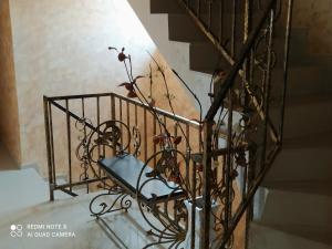 a metal stair railing with a plant on it at Dracena Guesthouse in Ravda