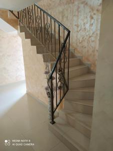 una escalera en una casa con barandilla de hierro forjado en Dracena Guesthouse en Ravda