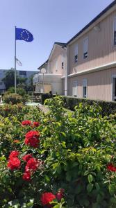 un arbusto de rosas rojas delante de un edificio en Quick Palace Nantes La Beaujoire, en Nantes