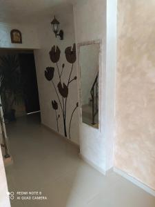 Zimmer mit einem Spiegel mit Blumen an der Wand in der Unterkunft Dracena Guesthouse in Rawda