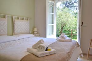 a bedroom with two beds with towels and a window at I Giardini di Camogli - VILLA SÀRVIA, garden&pool in Camogli