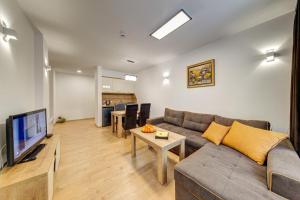 a living room with a couch and a tv at Smolyan Lakes Apartment / Апартамент Смолянски езера in Smolyan
