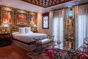 1 dormitorio con 1 cama, 1 silla y pinturas en Casa de Reyes, en Granada
