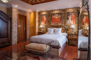 a bedroom with two beds and paintings on the wall at Casa de Reyes in Granada
