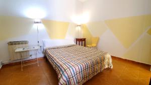 1 dormitorio con 1 cama, 1 mesa y 2 luces en Hostal Martes Cáceres Plaza Mayor - Tercer piso SIN ascensor, en Cáceres