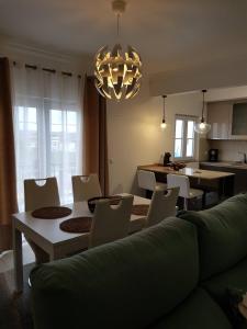 Una sala de estar con un sofá, una mesa y sillas. en Apartamento Alagoinha by Umbral, en Vila Nova de Milfontes