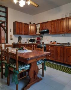 cocina con mesa de madera y armarios de madera en Appartamento Domusnovas, en Domusnovas