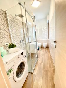 a washing machine in a bathroom with a shower at 15 minuti dall'Istituto Ortopedico Galeazzi - Appartamento Silenzioso con Cucina, WiFi e Netflix in Milan