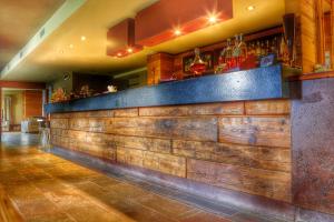 bar z drewnianą ścianą w restauracji w obiekcie Hotel La Chance w mieście Pila
